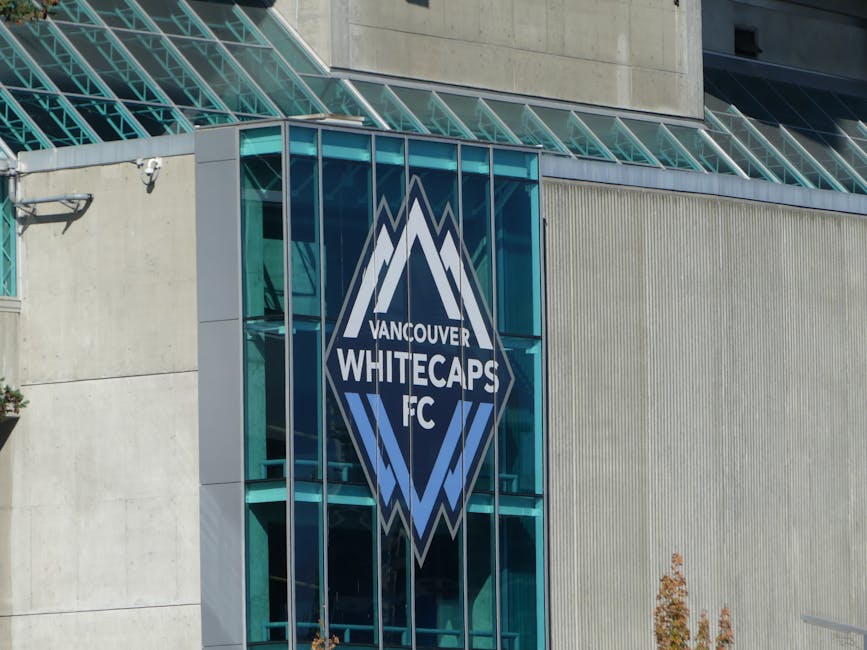 Close-up view of the Vancouver Whitecaps FC logo on the building's glass facade.